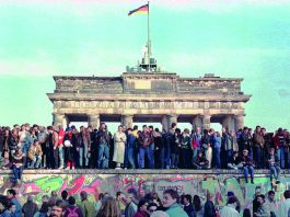 Buongiorno Berlino, 30 anni dopo 9/11, le immagini si rincorrono in queste ore sugli schermi a ricordare quel giorno di trent’anni fa che cambiò la storia, un punto di non ritorno che dimostrò che l’impossibile diventava possibile. I giorni di inizio novembre ’89 trascorrevano per me piuttosto tranquilli. Avevo concluso tutte le incombenze che mi avrebbero permesso, di lì a poco, di partire per un lungo periodo di studio oltre Atlantico e aspettavo impaziente quel momento atteso da anni. Ricordo bene luogo e ora dove ho appreso della “caduta del muro” e ognuno di noi credo lo ricordi, esattamente come tutti ricordiamo dove eravamo l’11 settembre e, per chi non è giovanissimo, la sera del primo passo dell’uomo sulla luna. E ricordo quell’amico, di una decina d’anni più anziano di me che aveva partecipato alla pagina tormentata del ’77 in Italia, il quale guardando la televisione, si girò e mi disse: “ma la tua che sottospecie di generazione è? Sei qui senza impegni di studio o lavoro particolari e non ti viene in mente di prendere un treno e andare là dove sta passando la storia? Potessi, io sarei già partito”. Detto, riflettuto e quasi fatto. Il tempo di convincere un’amica a fare il viaggio con me, la conta dei soldi per vedere se bastavano anche perché in famiglia nessuno doveva sapere di quell’avventura, e la notte seguente ero su un treno, direzione Berlino. Arrivammo in una città in fermento, sommersa da una massa umana fatta di sorrisi, urla gioiose, canti, emozioni, voglia di rivincita. Sudditi che tornavano cittadini e abbracciavano chi, quella libertà conquistata, aveva potuto viverla sempre. Era il sogno che diventava realtà di quelle parole scandite il 26 giugno 1963 davanti a un muro che non divideva una città ma il mondo intero, da un John Kennedy che si fece berlinese dicendo: “tutti gli uomini liberi, ovunque essi vivano sono cittadini di Berlino”. Come scrisse alcuni anni più tardi Enzo Bettiza in un suo libro, era la storia che “espugna il comunismo come una patetica Bastiglia e brucia i fantasmi del passato: le svastiche, i gulag, le spy stories di Le Carré con l'immancabile Check Point Charlie….” Fu una lezione di vita e non smetterò mai di ringraziare quell’amico che mi ha permesso di viverla, di poter dire oggi con orgoglio “c’ero anch’io” e non solo per il frammento di muro che come tutti mi sono messa nello zaino. E chissà che forse non dipenda proprio da quei magici giorni berlinesi se negli anni, partecipando a convegni e dibattiti, ho sempre preferito come data l’11/9 al 9/11 per identificare il vero spartiacque della storia. E non solo perché la seconda, con il suo bagno di violenza e di realtà, ha annientato il sogno di Berlino tra la polvere, rossa di sangue, delle Torri di Manhattan. L’11/9 si rialzava un muro da cui ne sarebbero sorti tanti altri mentre si dissolveva l’illusione di una nuova stagione di libertà e benessere per il mondo intero nata dodici anni prima sotto la porta di Brandeburgo. Neanche i muri più solidi si dice possono bloccare idee e persone. Lo diceva nel ’96, proprio sotto quella porta simbolo della Germania unita, anche Giovanni Paolo II, tra i principali artefici del crollo del blocco sovietico, mentre dichiarava che “l’uomo è chiamato alla libertà”. Ma quello di Berlino era un muro artificiale che aveva diviso uomini e donne che condividevano tutto: storia, ricordi, cultura e speranze. I primi vent’anni del nuovo millennio ci hanno invece consegnato altri muri, spesso frutto di secoli di culture diverse che, se ignorate, portano inevitabilmente a un rifiorire delle ideologie e a una loro prevaricazione sui valori della democrazia. I nostri giorni insegnano, con l’indebolimento sempre più evidente dei due principi su cui l’Europa si era fondata: responsabilità e solidarietà. Credo che solo rinsaldando la prima, anche con fermezza e regole chiare e certe, si possa tentare di recuperare la seconda. Non sarà facile ma ne vale la pena. Del resto chi, della mia generazione ma non solo, non ricorda “The Wall” dei grandi Pink Floyd che dicevano: “non è facile gettare il nostro cuore oltre quel maledetto muro. Ma un giorno mano nella mano lo attraverseremo”.