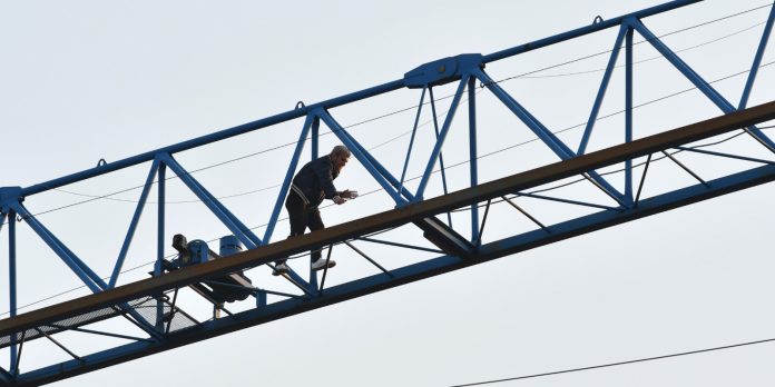 Si arrampica sulla gru in Piazza Broletto minacciando di buttarsi. Tiene inchiodati sanitari e forze dell'ordine per ore poi scende