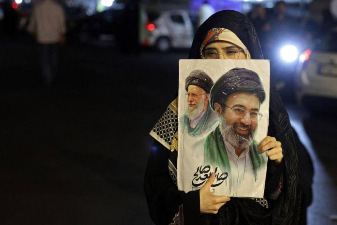 iran_donna_cartello_khamenei_afp