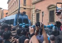 Morto ammanettato a Bologna, coro “assassini” e tensioni tra agenti e corteo: polizia usa idranti e lacrimogeni
