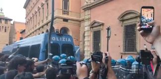 Morto ammanettato a Bologna, coro “assassini” e tensioni tra agenti e corteo: polizia usa idranti e lacrimogeni