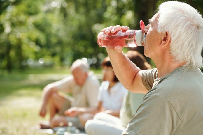caldo anziano che beve sole
