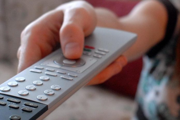 donna_ragazza_usa_il_telecomando_della_tv_televisione_guarda_tv-1