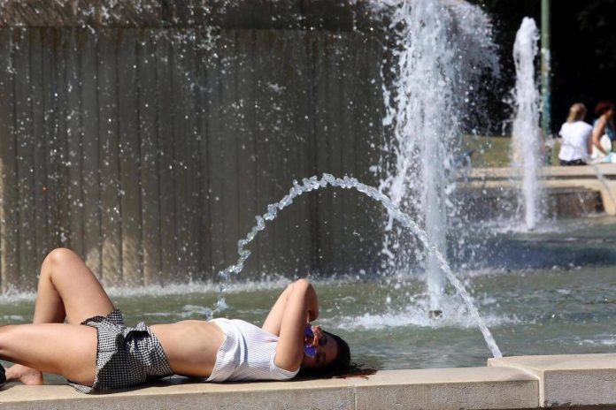 piazza_castello_turisti_si_rinfrescano_dal_caldo_nella_fontana